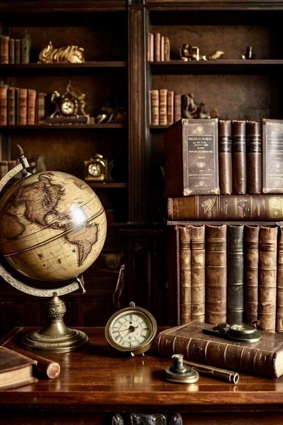 Antique books, a globe, and a brass desk clock in a study