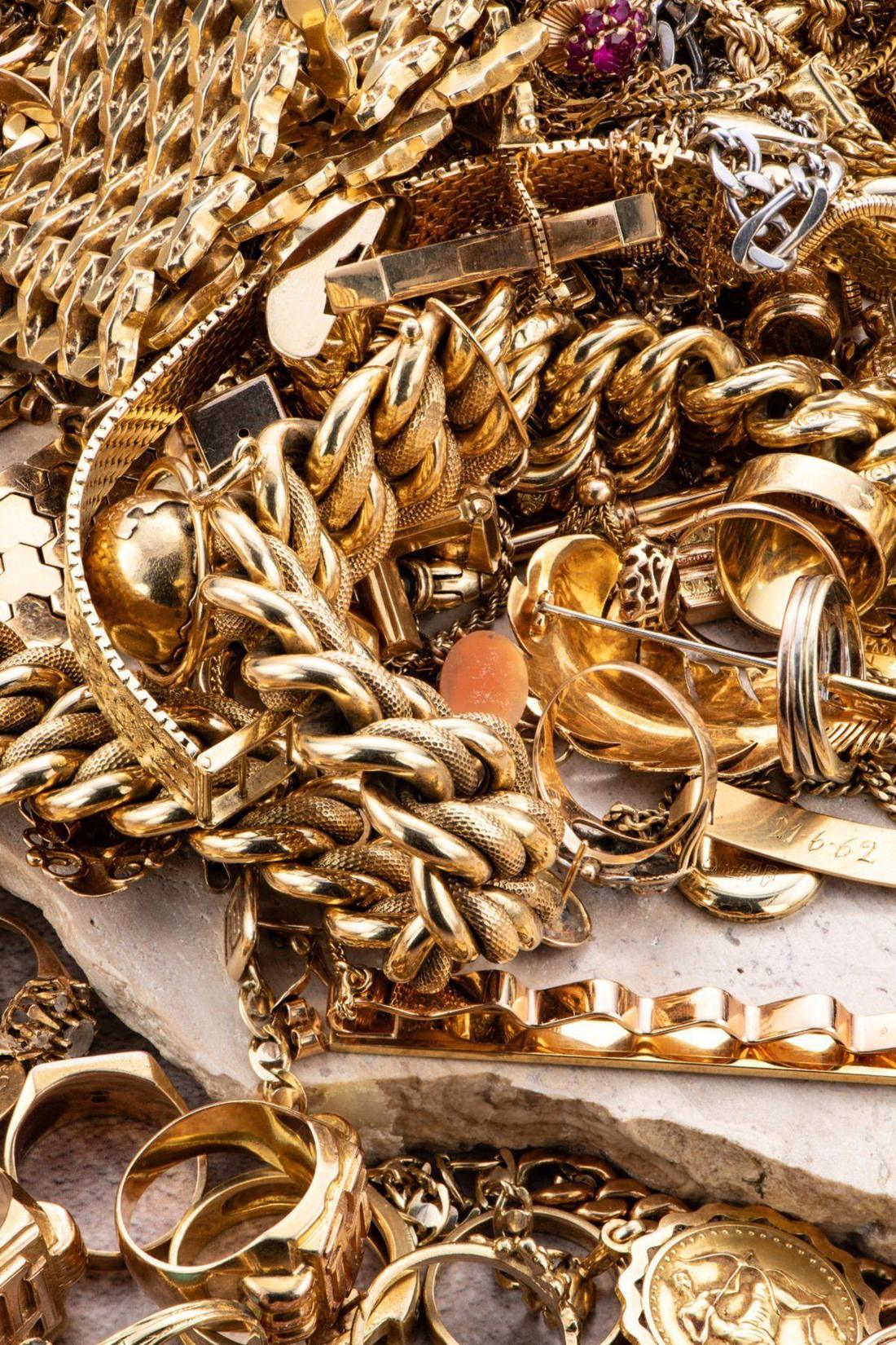 A pile of mixed gold jewelry — chains, rings, bracelets